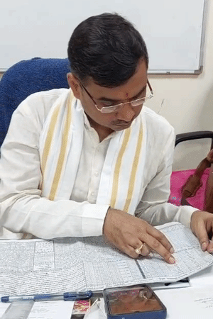 BHU के ज्योतिषाचार्य प्रोफेसर विनय पांडेय ने मुहूर्त बताने से पहले वार्षिक पत्रा का अध्ययन किया।