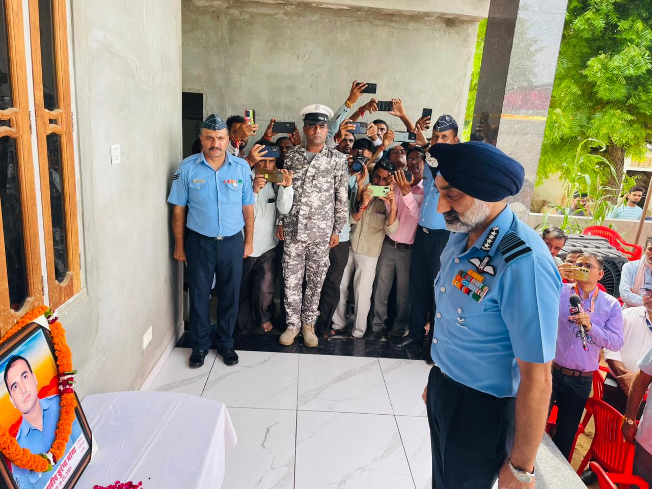 शहीद सुरेंद्र मोगा के घर उनकी तस्वीर के सामने एयर चीफ मार्शल अमरप्रीत सिंह।