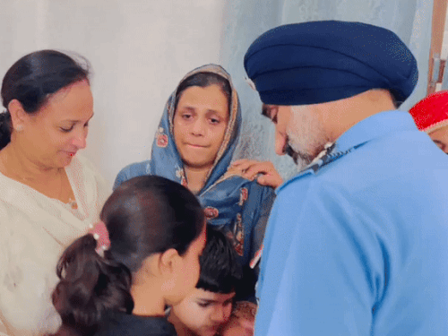 शहीद सुरेंद्र मोगा की बेटी वृतिका को दुलार करते एयर चीफ मार्शल और उनकी पत्नी (सफेद कुर्ती में)