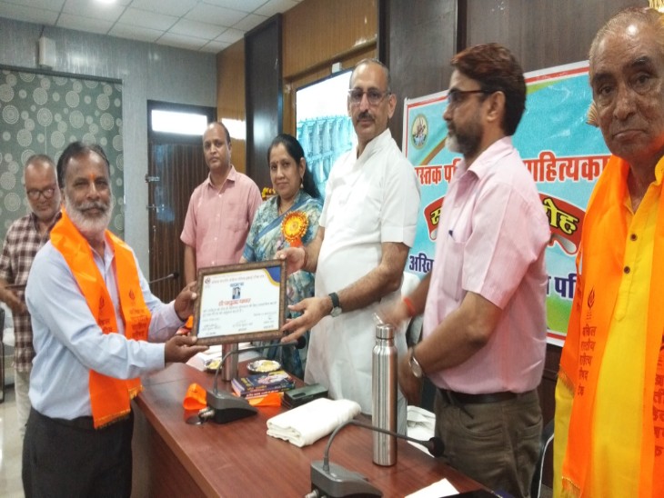 समारोह में साहित्यकार को सम्मानित करते अतिथि।