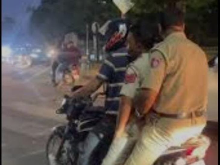 बिना हेल्मेट के बाइक पर जाते हुए।