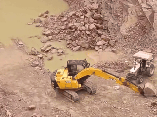 खनन के लिए रखी हुई मशीन और ट्रैक्टर ट्रॉली।