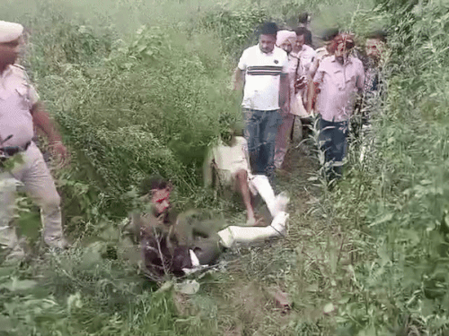 रेंगते हुए पुलिस को लूटा हुआ कैश रिकवर कराते हुए बदमाश।