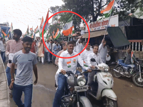 बाइक पर बैठे राजस्व मंत्री हेमंत मीणा के हाथ में तिरंगा उल्टा नजर आया।