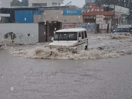 पालवास रोड पर जलभराव के बीच गुजरते वाहन।