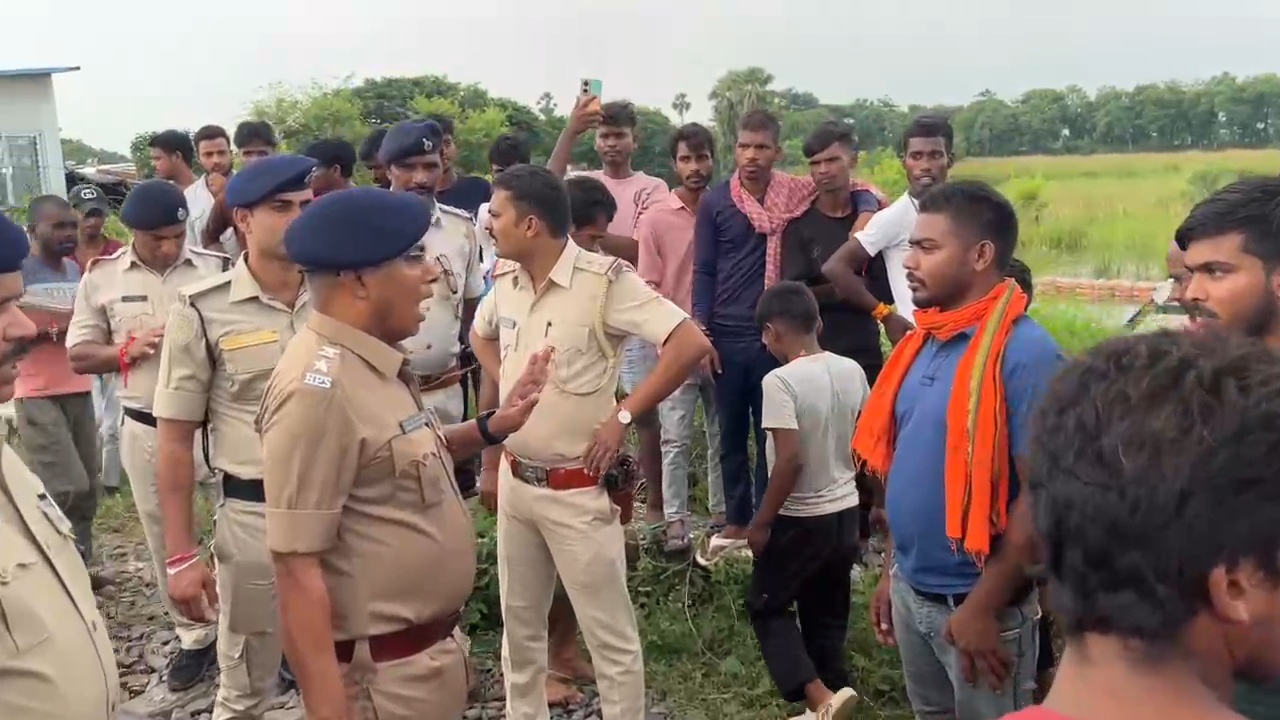 आक्रोशित लोगों को समझाती पुलिस।