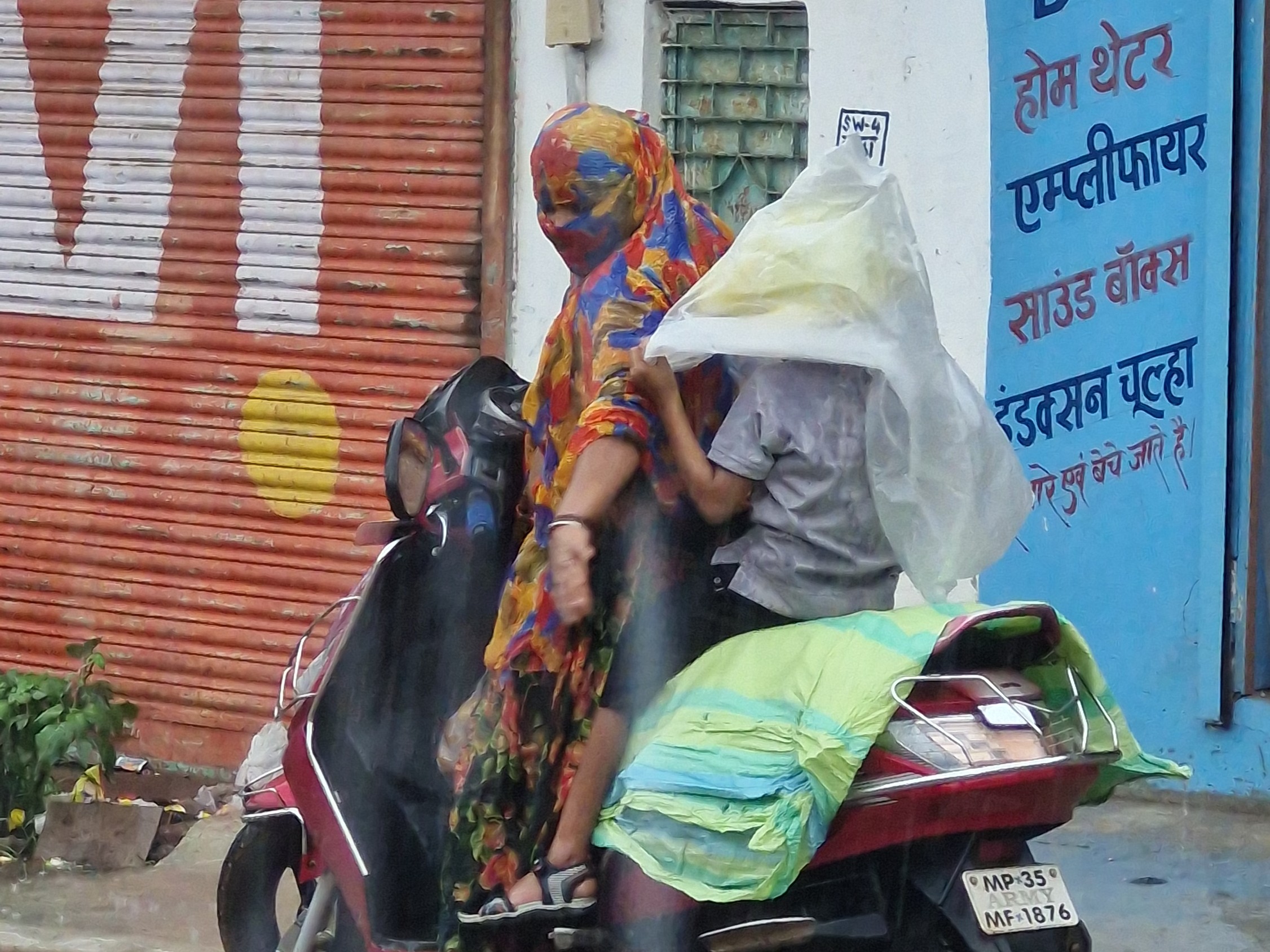 बारिश से भीगते हुए मां-बेटे परेशान।