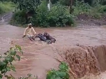 राम कटोरा से वरला रोड के नाले में आई बाढ़ से बाइक बही।