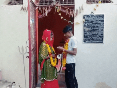 लड़के ने लड़की को मंगलसूत्र पहनाया, फिर एक दूसरे को मिठाई खिलाई।