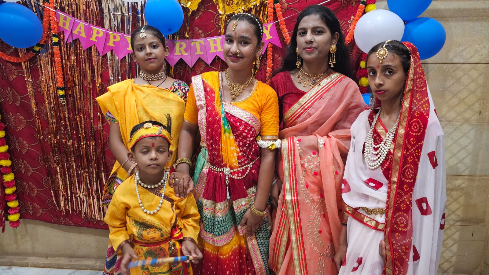 कृष्ण भगवान को हैप्पी बर्थडे बोलकर जन्मदिन मना रहे बच्चे।