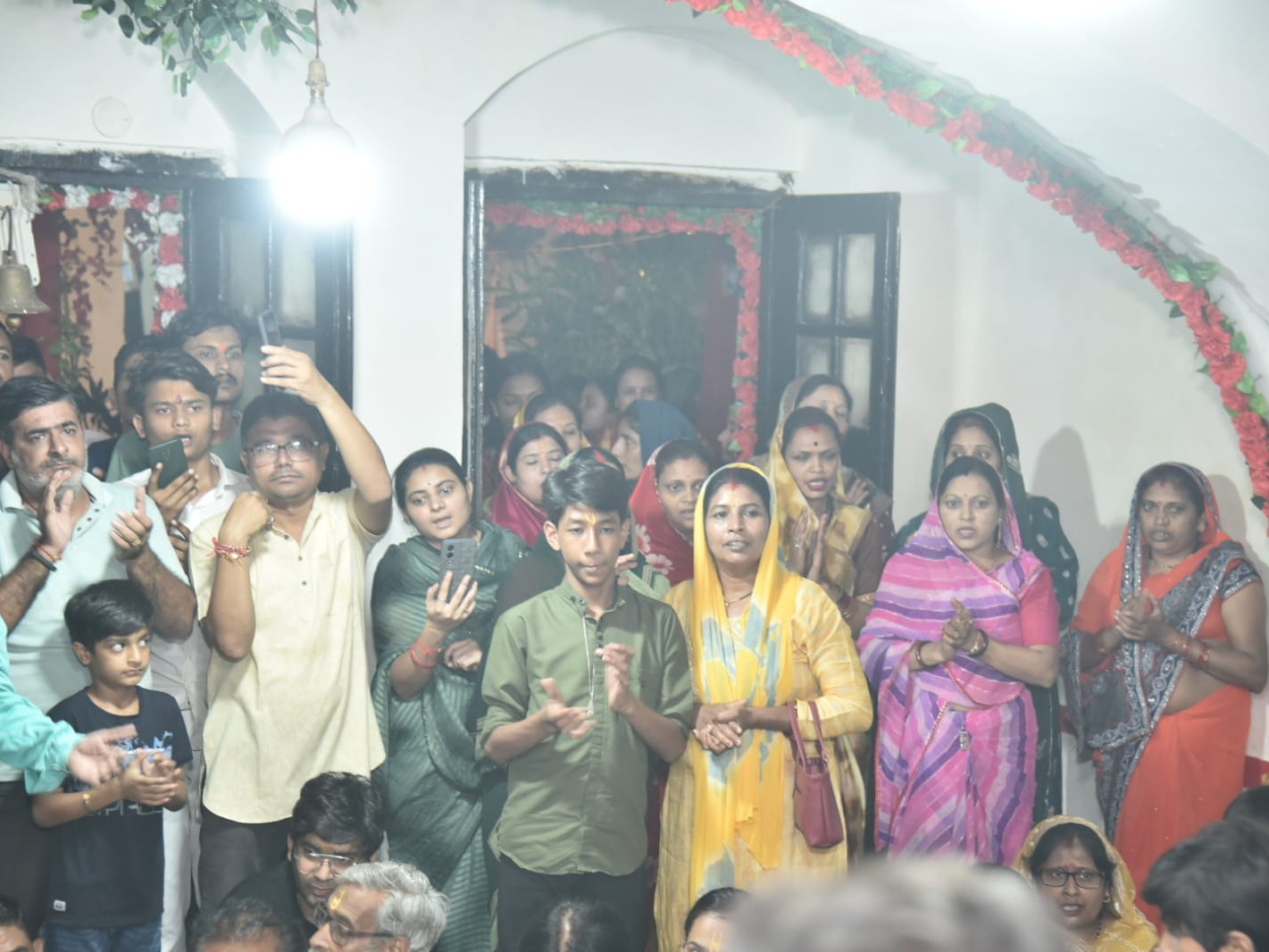 कान्हा के रूप का फोटो लेते भक्तगण।
