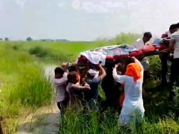 अंतिम संस्कार के लिए पानी और कीचड़ से भरे रास्ते से गुजरते हैं ग्रामीण।