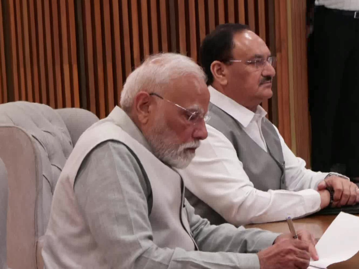 बैठक में कुछ नोट करते प्रधानमंत्री नरेंद्र मोदी। भाजपा अध्यक्ष जेपी नड्डा भी मौजूद हैं।