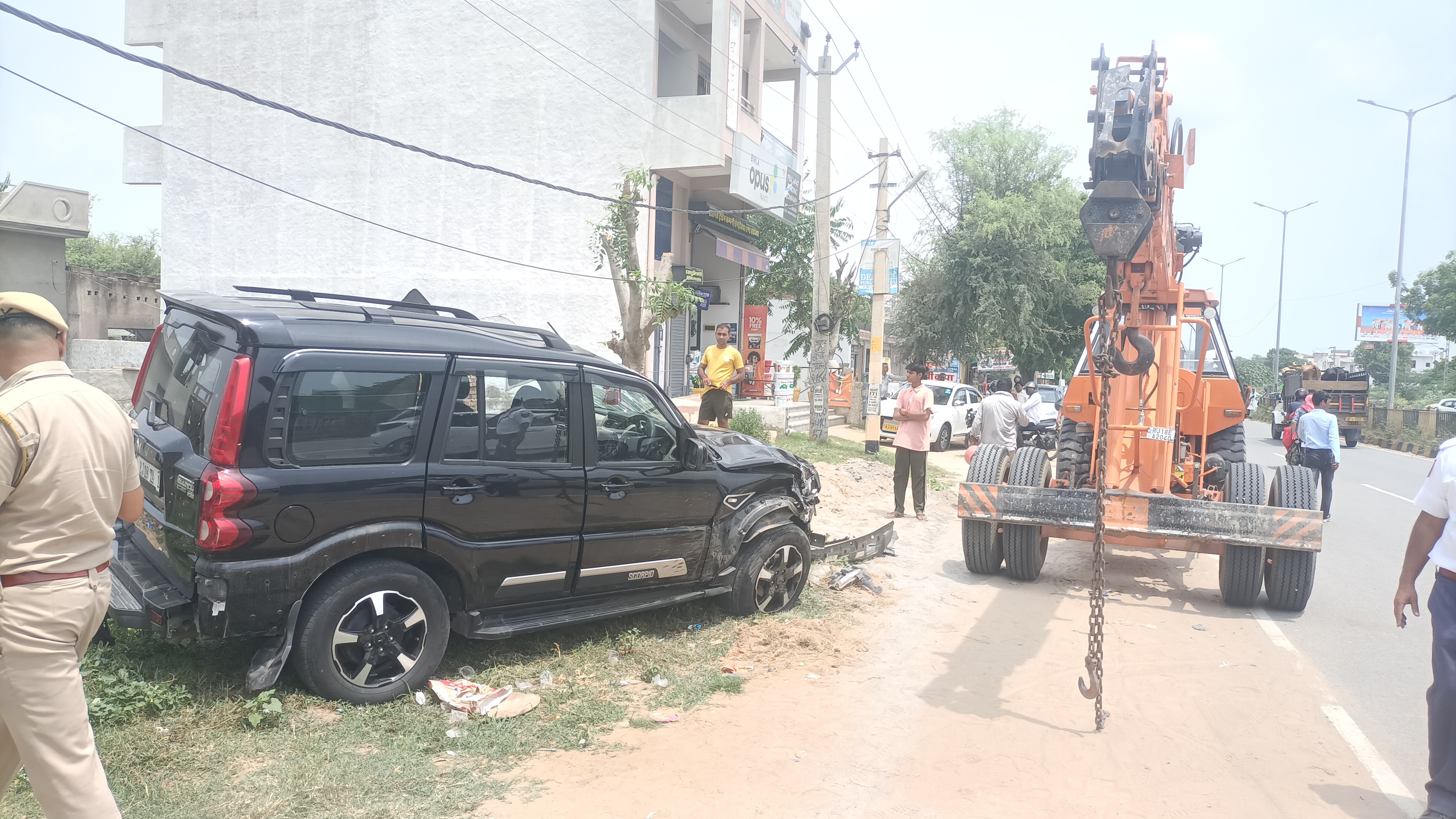 क्रेन की मदद से सड़क से हटाई जा रही क्षतिग्रस्त स्कॉर्पियो, पुलिस ने शुरू की जांच।