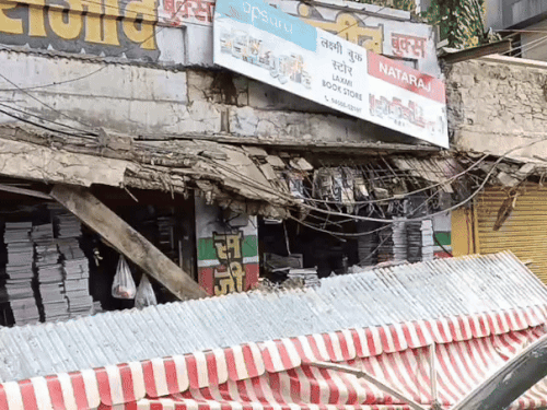 बुक स्टोर का गिरा छज्जा, जिससे दो लोग चोटिल हुए।