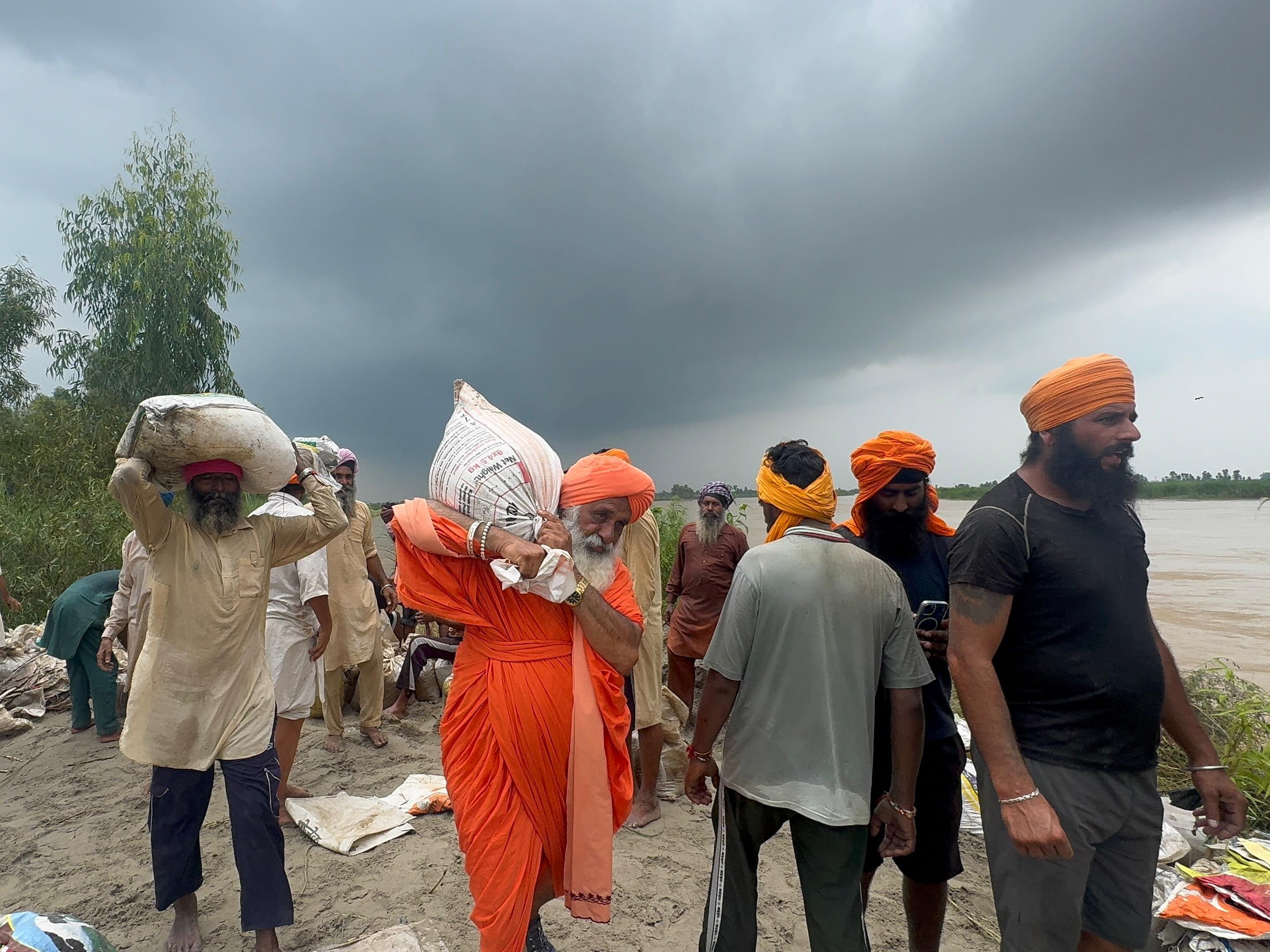 संत सीचेवाल खुद बोरियां उठाकर लोगों तक पहुंचा रहे हैं।