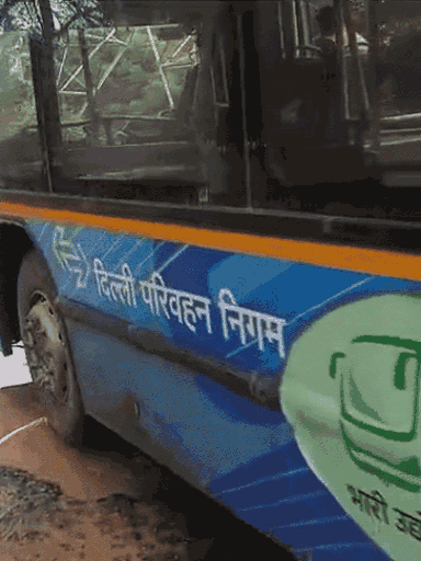 बहादुरगढ़ में सड़क में हुए गड्‌ढे से गुजरती दिल्ली परिवहन निगम की बस।