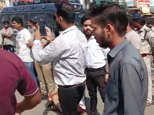 सड़क पर बैठकर नारेबाजी करते बजरंग दल कार्यकर्ता।