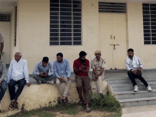 हवाई पट्टी के बाहर इंतजार करते हुए लोग।