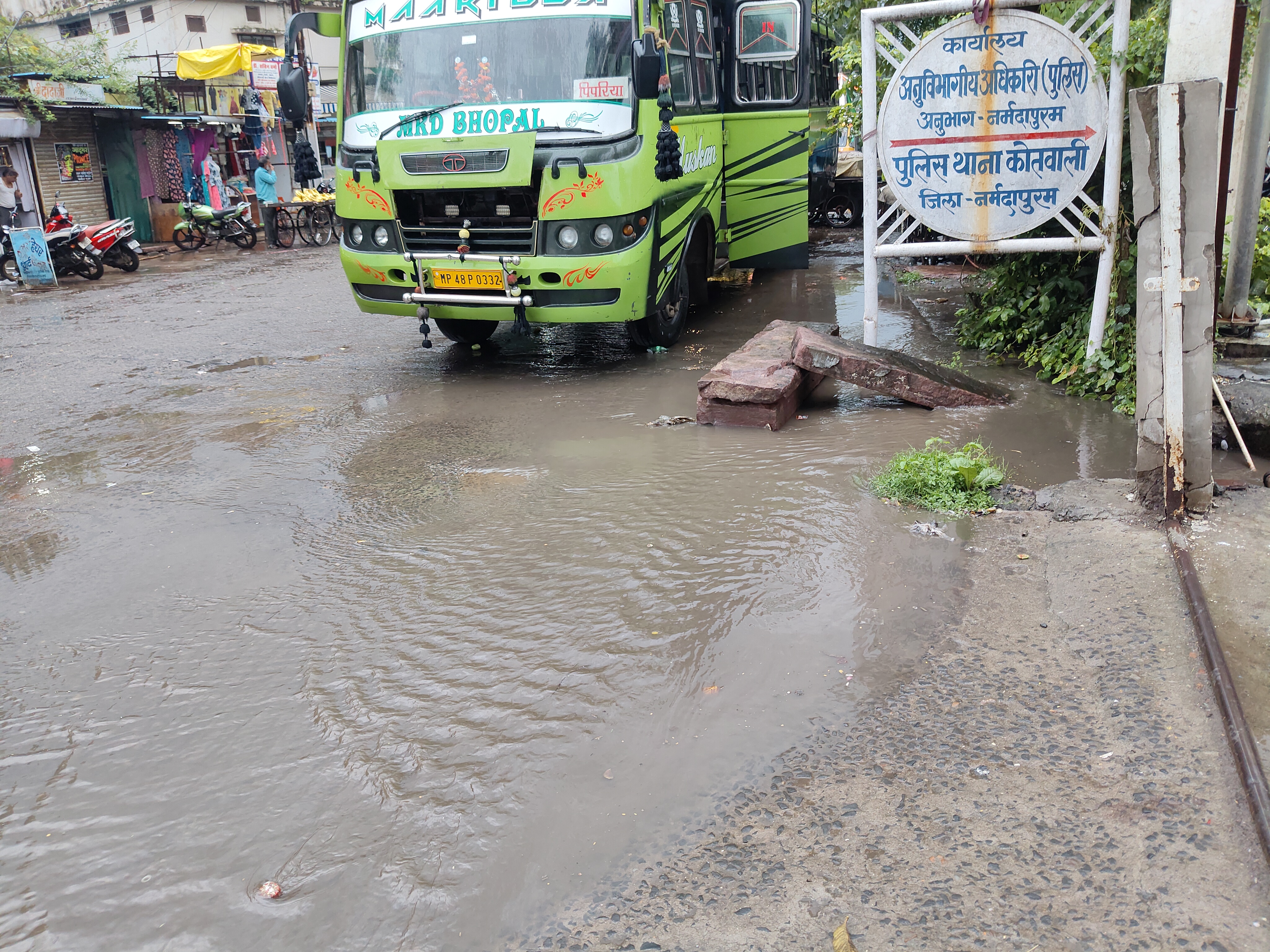 थाने के सामने नाली में कचरा फंसा होने से गंदा और बरसाती पानी सड़क पर आ गया।