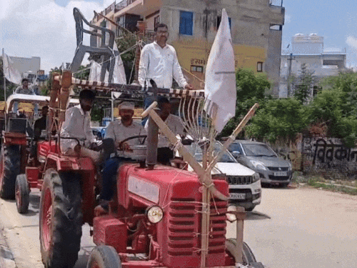बंद के बीच ट्रैक्टर रैली में एक किसान अपने ट्रैक्टर पर चारपाई डालकर लाया।