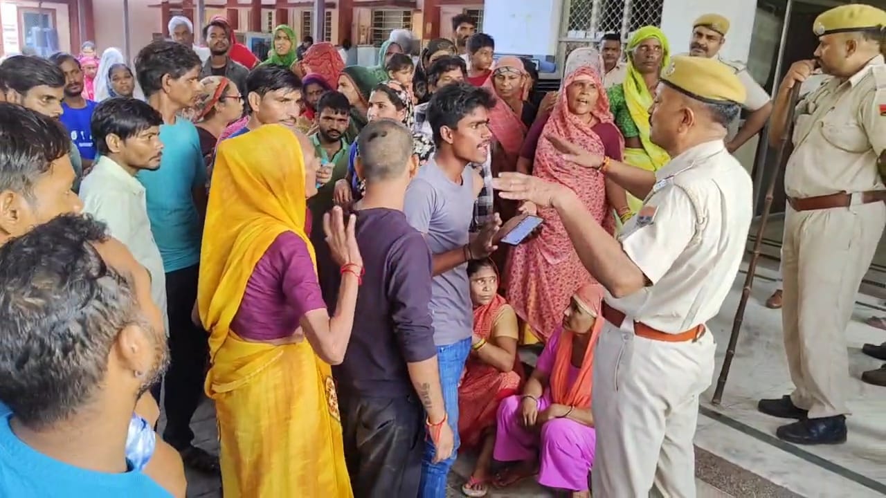 पुलिसकर्मी महिला के परिजनों से समझाइश करते हुए।