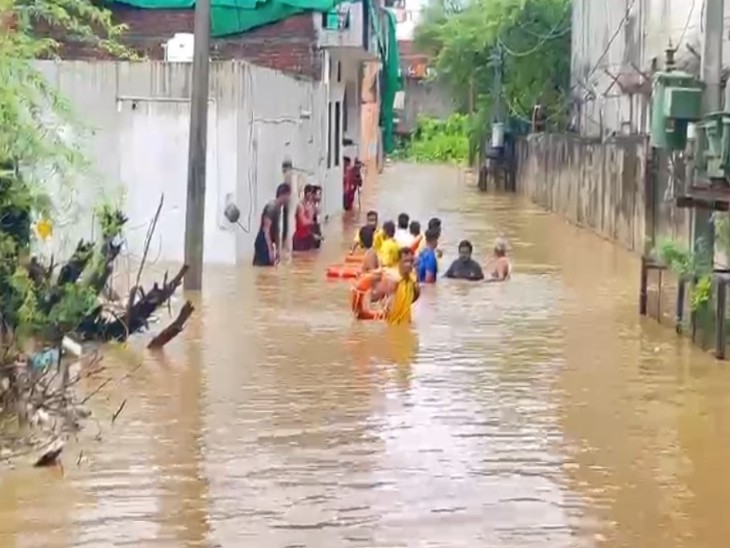 लोगों को वनस्थली में जल भराव में से सुरक्षित स्थान पर निकलती SDRF की टीम।