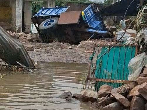 पानी के बहाव के कारण एक घर के बाहर खड़ी ट्रोली पलट गई।