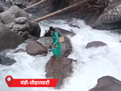 Kamla crossing the drain in Mandi's Chauharghati