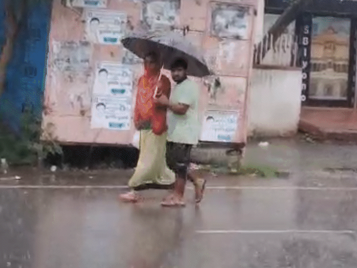 लगातार हो रही तेज बारिश के बीच लोग काम पर जाते नजर आए।