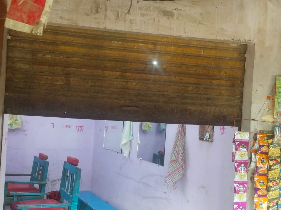 गोली लगने से हेयर सेलून के शटर में छेद हो गया।