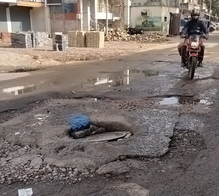 जर्जर हालात में सड़क और मेनहोल