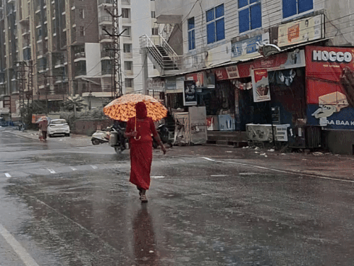 अजमेर में बरसात के दौरान जरूरी काम होने पर लोग घरों से छाते लेकर निकले।