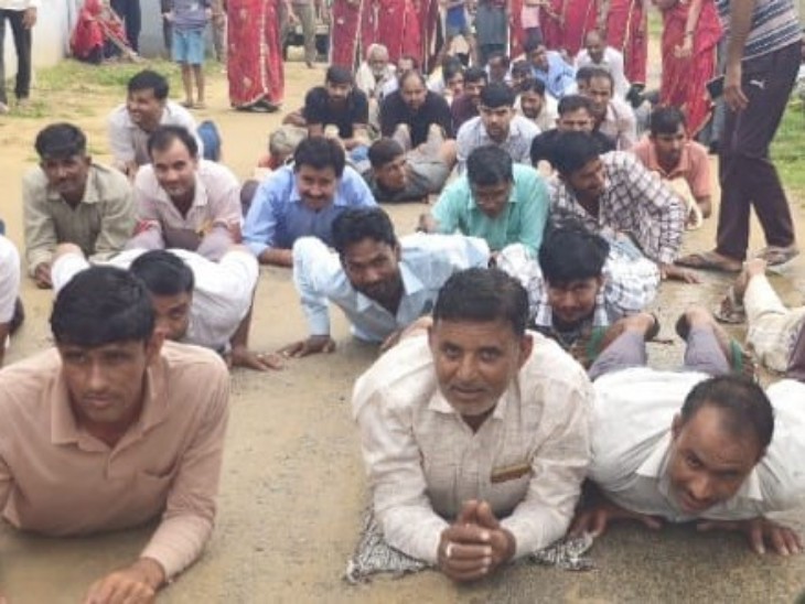 सड़क पर लेटकर विरोध-प्रदर्शन करते हुए ग्रामीण।