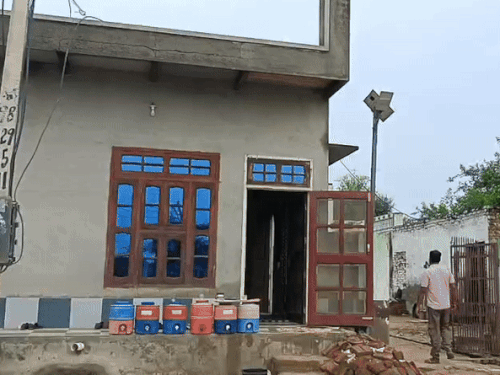 पास के घर में एक बैठक में आने-जाने वालों के लिए ठंडे पानी के कैंपर रखे हुए हैं।