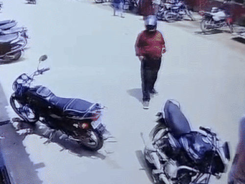 हेलमेट पहने हुए एक व्यक्ति पहले बाइक के पास आया।