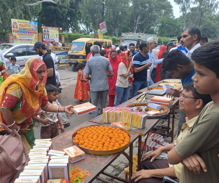 नागा बाबा बगेची के बाहर प्रसाद खरीदते हुए श्रद्धालु।