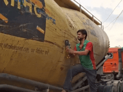 शराब के कार्टून निकालने के लिए टैंकर को काटते हुए।