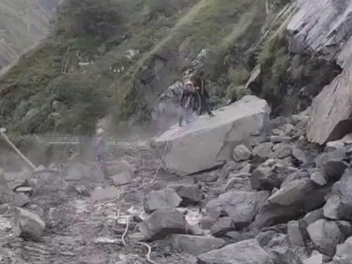 Workers removing rocks falling on the road in Nathpa on Shimla-Kinnaur NH.