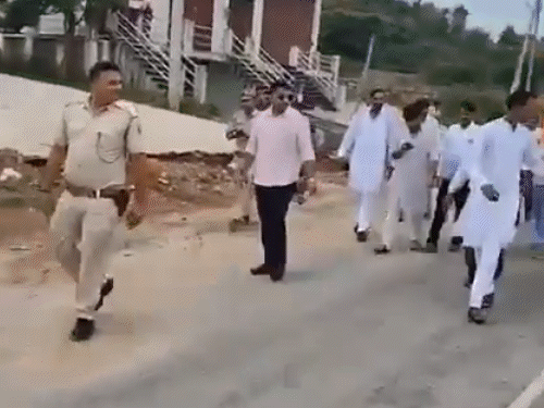 रैली के दौरान विधायक ढोल वाले को लात से आगे बढ़ने के लिए कहते हुए।