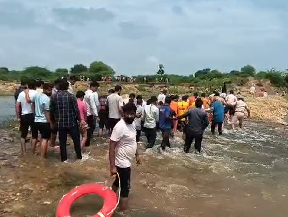 शव लेकर नदी पार करते एसडीआरएफ और सिविल डिफेंस की टीम।