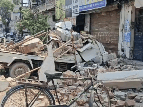 दीवार और छत गिरने से क्षतिग्रस्त वाहन।