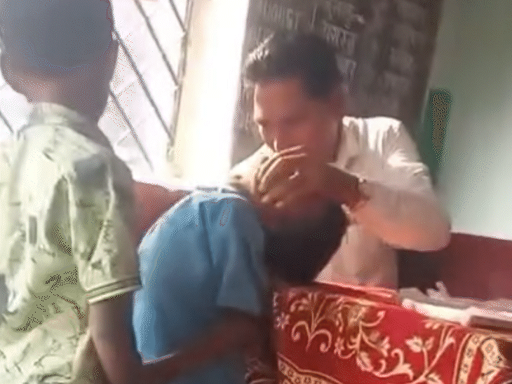 In the video, the teacher is seen pressing the student's face.
