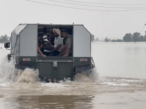 Ephibian vehicles landing in water to help people trapped in floods.