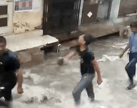 बारिश के पानी में खेलते स्कूली बच्चे