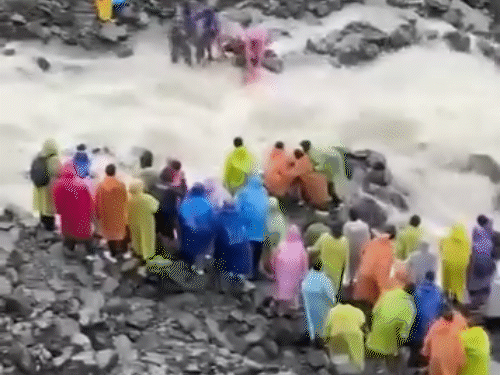 मणिमहेश यात्रा पर गए श्रद्धालु जान जोखिम में डालकर उफनते नाले को पार करते हुए।