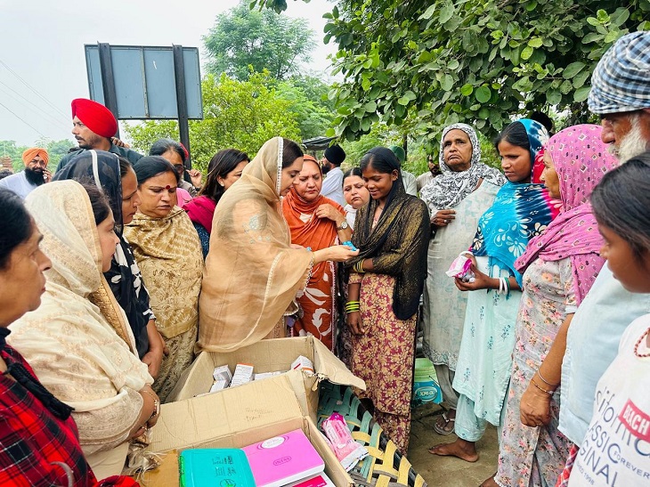AAP की महिला विंग की स्टेट प्रेसिडेंट महिलाओं को दवाइयां और अन्य सामान देते हुए।