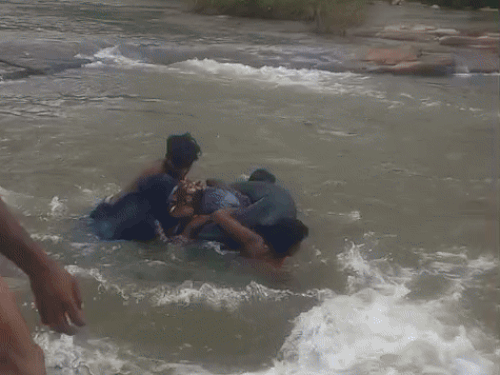 इन लोगों ने बुखार से पीड़ित महिला को ट्यूब पकड़ाई और फिर उसके साथ नदी में उतर गए।