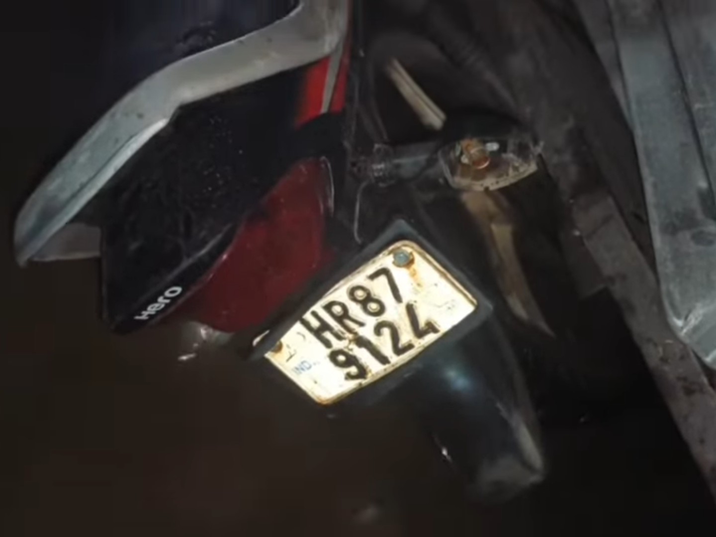 ट्रॉली के नीचे दबकर टूटी बाइक।