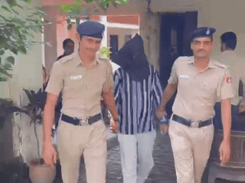 आरोपी को ले जाती पुलिस।
